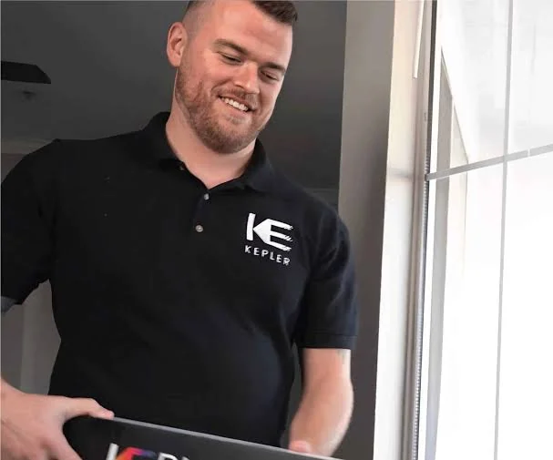 Kepler representative discussing window-film samples beside residential glass