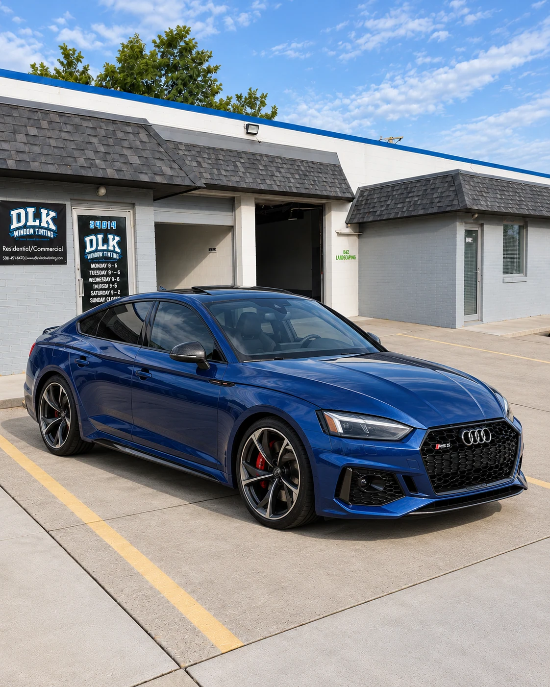 Illustration of a metallic deep blue Audi RS5 Sportback with tinted windows outside DLK's Mount Clemens shop