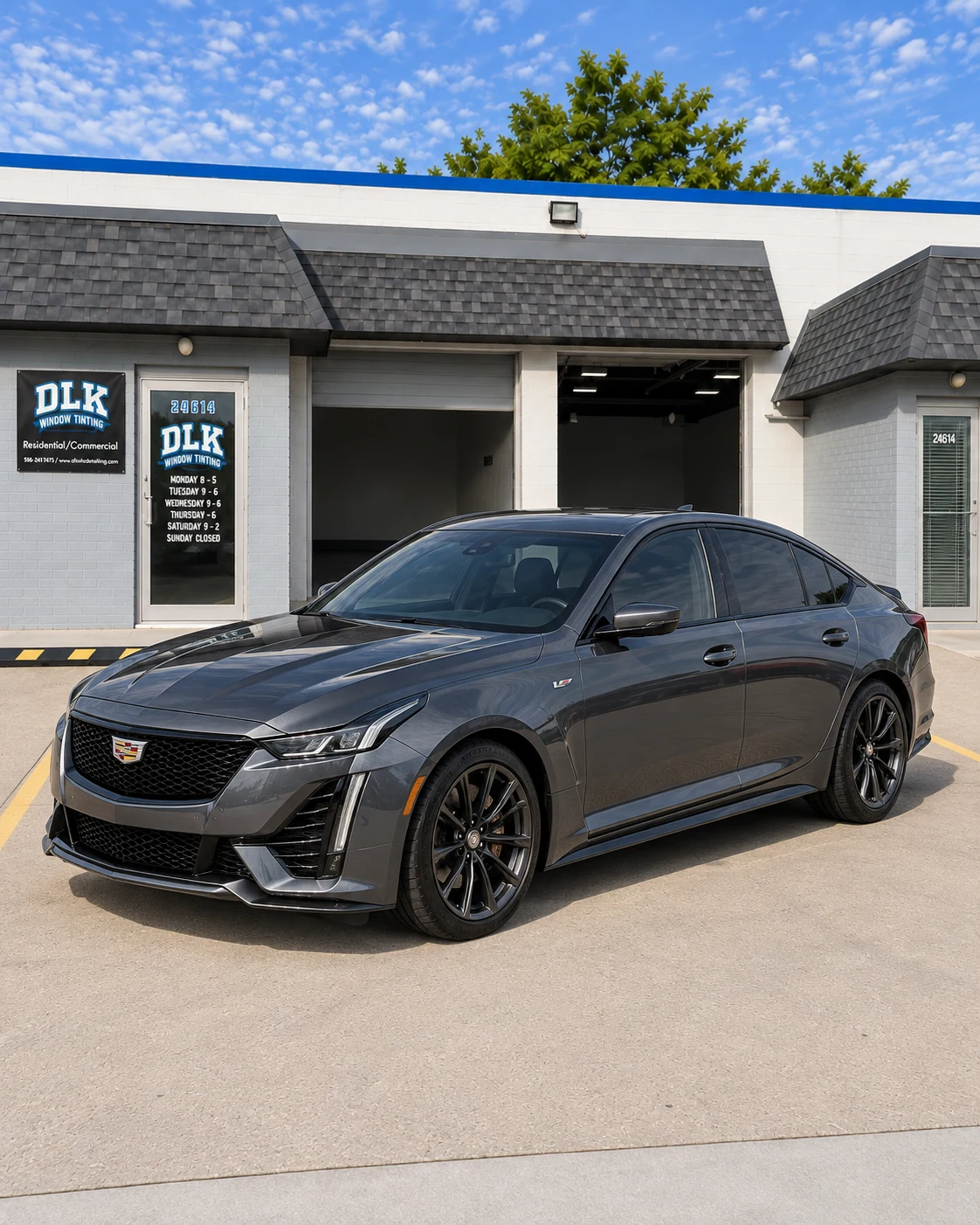 Illustration of a graphite grey Cadillac CT5-V sedan with tinted windows outside DLK's Mount Clemens shop