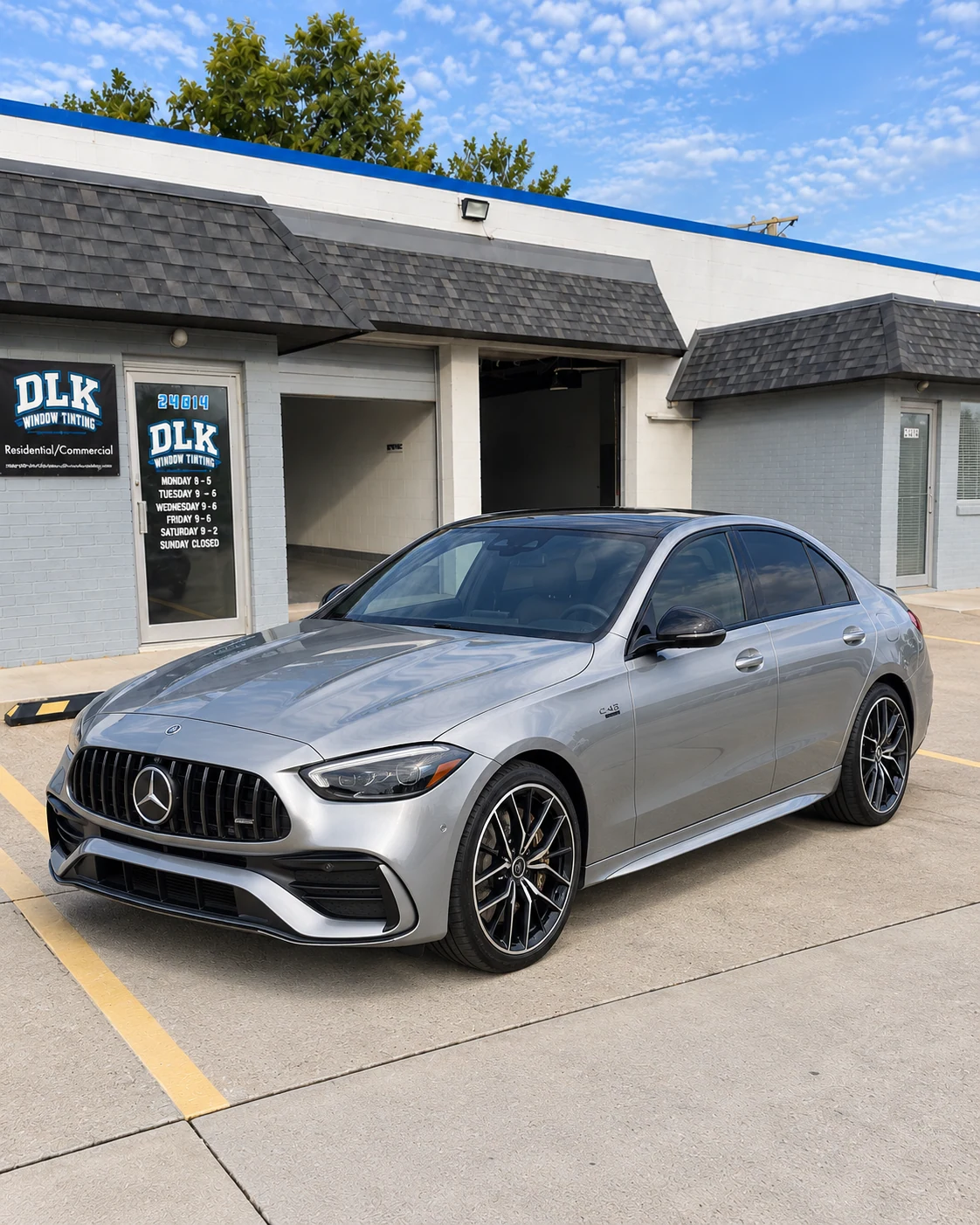 Illustration of a selenite silver-grey Mercedes-Benz C43 sedan with tinted windows outside DLK's Mount Clemens shop