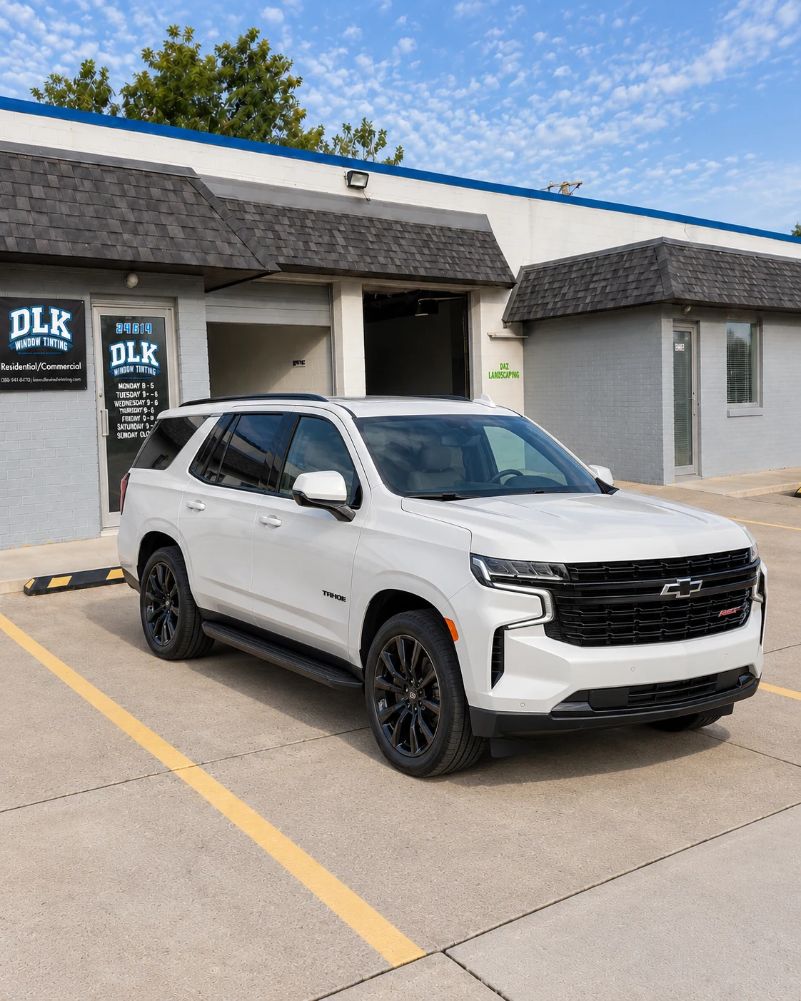 Illustration of a pearl white Chevrolet Tahoe RST with tinted windows outside DLK's Mount Clemens shop