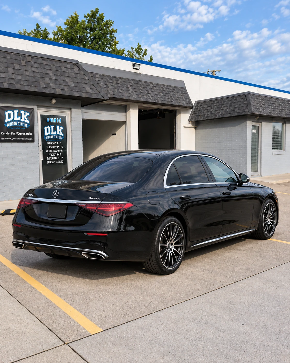 Illustration of a gloss black Mercedes-Benz S-Class W223 sedan with tinted windows outside DLK's Mount Clemens shop
