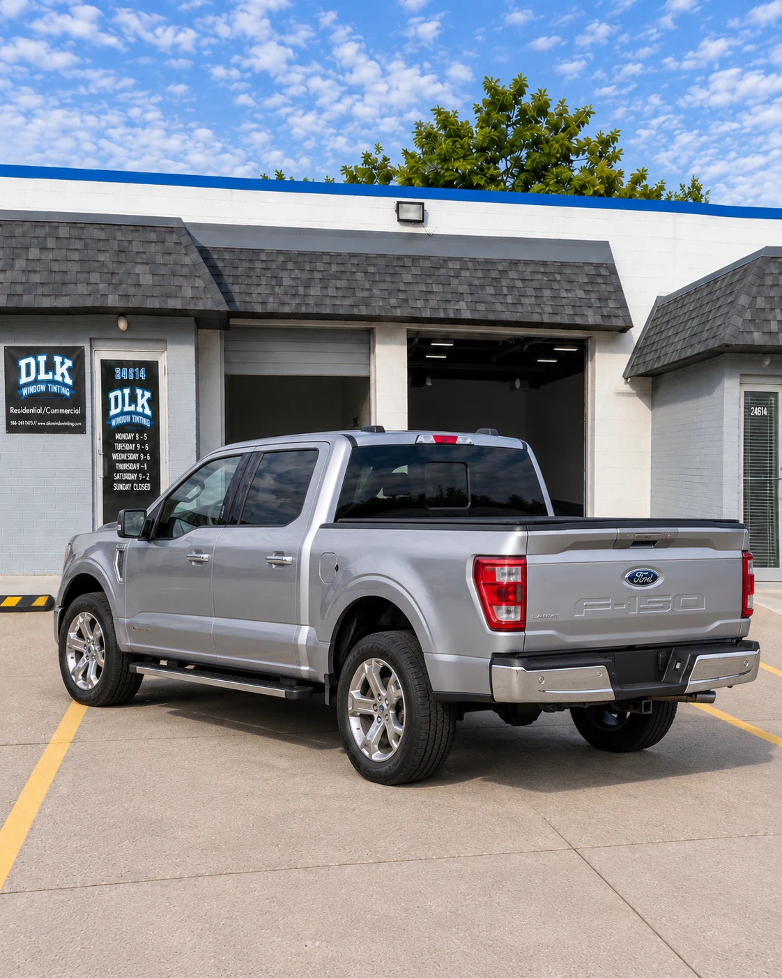 Illustration of a silver metallic Ford F-150 Lariat crew cab with tinted windows outside DLK's Mount Clemens shop