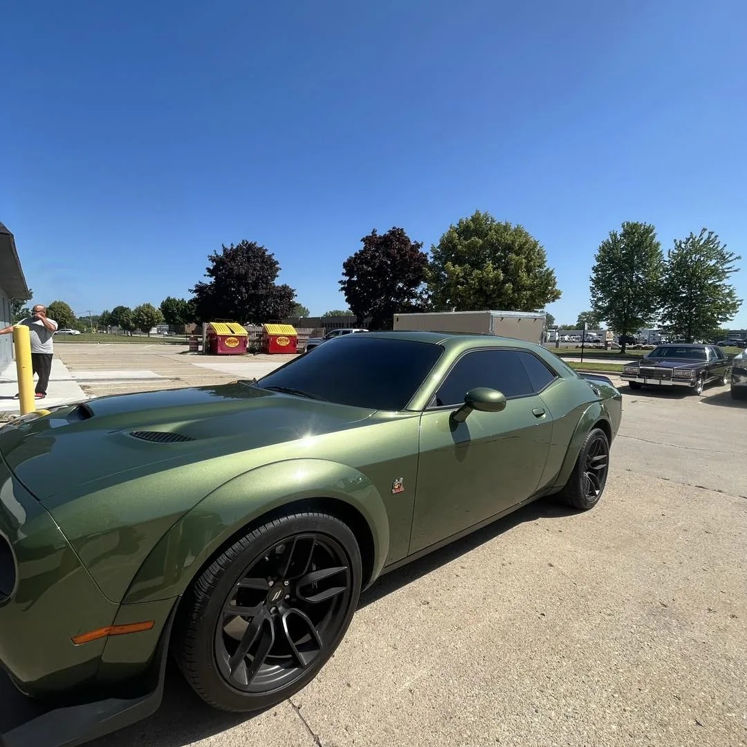 Green Dodge Challenger with dark window tint in the DLK Window Tinting lot