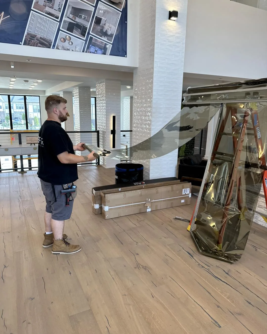 DLK Window Tinting installer preparing window film in a building lobby