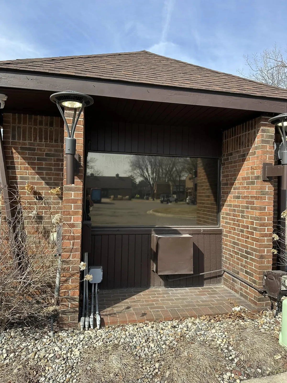 Brick office entrance with a large window fitted with window film