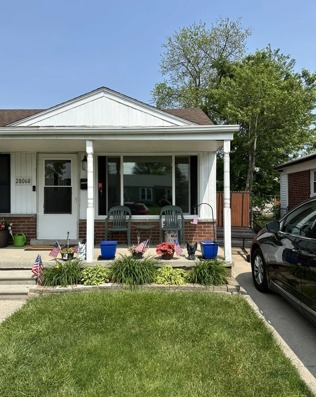 Front windows of a home with a covered porch, fitted with window film
