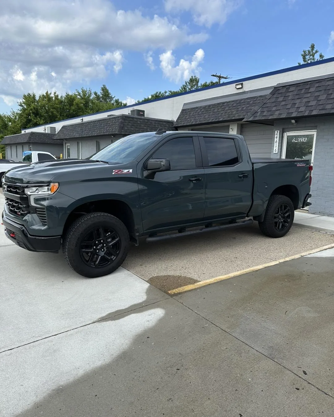 Dark grey Chevrolet Silverado with tinted windows at the DLK Window Tinting shop