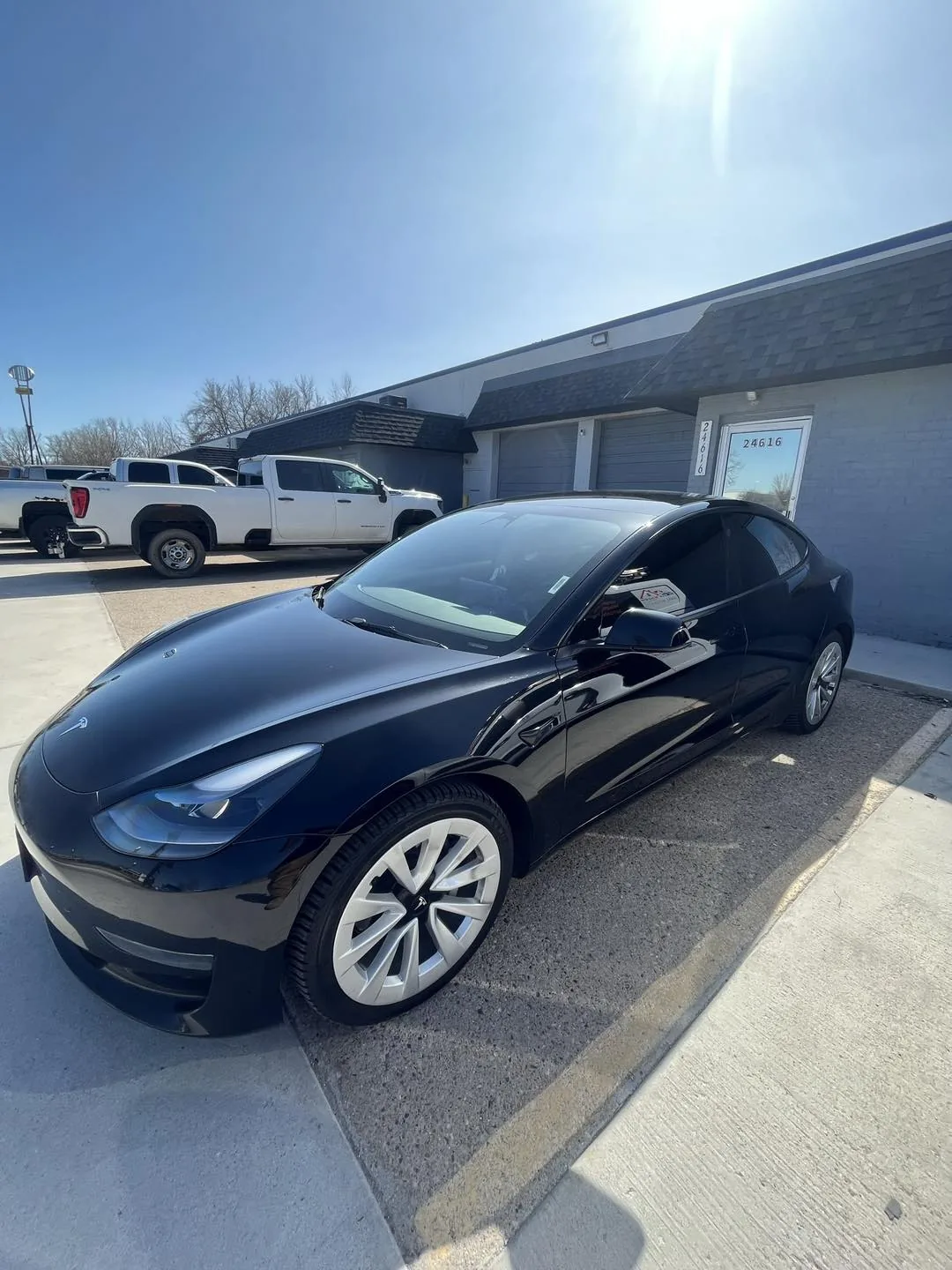 Black Tesla Model 3 with tinted windows parked at DLK Window Tinting