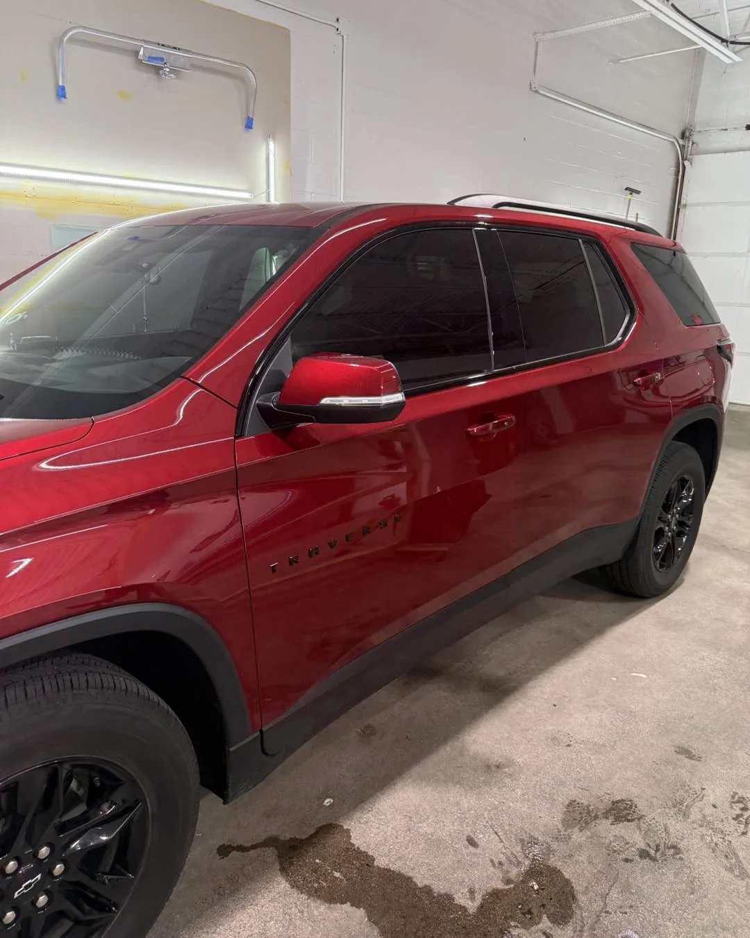 Red Chevrolet Traverse with tinted side windows